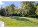 Lush backyard featuring a wooden playset, mature trees, and well-maintained lawn, perfect for Gathering fun at 7249 Red Maple Dr, Zionsville, IN 46077