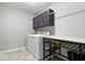 Functional laundry room with modern appliances, cabinetry, and a folding station at 7249 Red Maple Dr, Zionsville, IN 46077