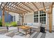 Inviting outdoor patio with wicker furniture, pergola, string lights, and stylish rug at 7249 Red Maple Dr, Zionsville, IN 46077