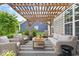 Outdoor patio seating area with pergola, string lights, and comfortable wicker furniture at 7249 Red Maple Dr, Zionsville, IN 46077