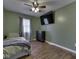 Bedroom includes wood-look floors, fresh green paint, TV, ceiling fan and nice decor at 730 N Forsythe St, Franklin, IN 46131
