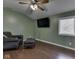 Small green bedroom with a leather chair, ottoman, tv, ceiling fan, and a window at 730 N Forsythe St, Franklin, IN 46131