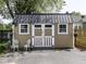 Exterior of a well-maintained backyard shed with painted wood siding, windows, carriage doors and furniture at 730 N Forsythe St, Franklin, IN 46131