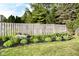 Landscaped backyard with green grass, flower beds, and a wooden fence at 7657 Winding Creek Dr, Indianapolis, IN 46236