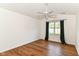 Bright bedroom with new vinyl floors, fan, and a large window overlooking the outdoor scenery at 7657 Winding Creek Dr, Indianapolis, IN 46236