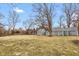 Spacious backyard featuring green grass and mature trees, providing an ideal outdoor setting at 7999 Englewood Rd, Indianapolis, IN 46240