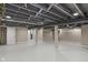 Spacious basement featuring exposed ceiling beams, painted floors, and neutral walls at 7999 Englewood Rd, Indianapolis, IN 46240