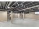 Large basement area with open ceiling, painted floor, and neutral color scheme at 7999 Englewood Rd, Indianapolis, IN 46240