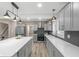 Spacious kitchen with grey cabinets, stainless steel appliances, modern lighting, and large island at 7999 Englewood Rd, Indianapolis, IN 46240