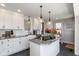 Modern kitchen with white cabinets, granite countertops and island with cooktop at 831 Weghorst St, Indianapolis, IN 46203