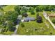 Aerial shot of a property showcasing the home, detached garage, long driveway, and spacious, green surroundings at 8510 N Carroll Rd, Indianapolis, IN 46236