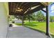 Large concrete patio with wooden beam cover featuring a ceiling fan and expansive backyard views at 8510 N Carroll Rd, Indianapolis, IN 46236