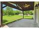 Spacious covered patio with a ceiling fan overlooking a well-manicured lawn and detached garage at 8510 N Carroll Rd, Indianapolis, IN 46236