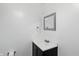 Powder room features a sink and dark wood vanity, silver framed mirror, and white walls at 8510 N Carroll Rd, Indianapolis, IN 46236