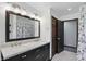A bathroom with double sinks and a large mirror above and a shower with a blue shower curtain at 8510 N Carroll Rd, Indianapolis, IN 46236