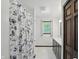 Bright bathroom with marble floors, a shower with a blue and white curtain, and plenty of natural light at 8510 N Carroll Rd, Indianapolis, IN 46236