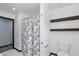 Bathroom with tiled floors, shower with curtain, toilet, and dark wood shelves at 8510 N Carroll Rd, Indianapolis, IN 46236