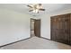 An empty room features carpet, a fan, a large closet, and a door leading into another room at 8510 N Carroll Rd, Indianapolis, IN 46236