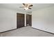 A carpeted bedroom with a ceiling fan features two closets and a doorway at 8510 N Carroll Rd, Indianapolis, IN 46236
