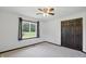 Bedroom with a ceiling fan and window showing backyard, and closet with brown doors at 8510 N Carroll Rd, Indianapolis, IN 46236