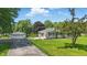 Well-kept home featuring a detached garage, long driveway, and manicured lawn with mature landscaping at 8510 N Carroll Rd, Indianapolis, IN 46236