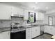 Galley kitchen featuring stainless steel appliances and bright white cabinets at 8510 N Carroll Rd, Indianapolis, IN 46236