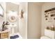 Stylish powder room with pedestal sink, decorative mirror, and patriotic wall decor at 9263 Wadsworth Ct, Fishers, IN 46037