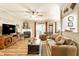 Cozy living room featuring a fireplace, hardwood floors, ceiling fan, and neutral-toned furniture at 9263 Wadsworth Ct, Fishers, IN 46037