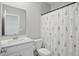 Bright bathroom with a floral shower curtain, white vanity, and a large framed mirror at 9537 Crossfield Rd, Avon, IN 46123