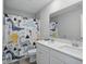 Bathroom featuring dual sink vanity with stone countertop and a dinosaur themed shower curtain at 9537 Crossfield Rd, Avon, IN 46123