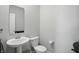 Clean and modern powder room with a pedestal sink, toilet, and neutral color palette at 9537 Crossfield Rd, Avon, IN 46123