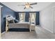 Comfortable bedroom with a decorative headboard, ceiling fan and two windows for natural light at 9709 Prairie Smoke Dr, Noblesville, IN 46060