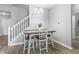 Dining room showcasing natural lighting, stairs leading up, laminate floors, and a wooden table at 9709 Prairie Smoke Dr, Noblesville, IN 46060