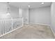 Bright hallway with carpet, white railings, and modern lighting at 9709 Prairie Smoke Dr, Noblesville, IN 46060