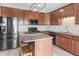 Bright kitchen with wood cabinets, stainless steel appliances, granite counters, and island with barstool seating at 9709 Prairie Smoke Dr, Noblesville, IN 46060