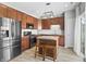 Modern kitchen features wood cabinets, stainless steel appliances, island with seating, and bright natural light at 9709 Prairie Smoke Dr, Noblesville, IN 46060