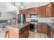 Stylish kitchen with wood cabinets, stainless appliances, granite counters, kitchen island with seating, and modern lighting at 9709 Prairie Smoke Dr, Noblesville, IN 46060