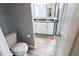 Well-lit bathroom with toilet and double sink vanity with gray countertop and a shower at 10628 Bali Ct, Noblesville, IN 46060
