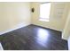 An empty bedroom with new dark floors and pale yellow walls at 10628 Bali Ct, Noblesville, IN 46060