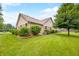 Brick house backyard with lush lawn, trimmed bushes, and trees, providing a serene outdoor environment at 1105 Sarah Ct, Greenwood, IN 46142