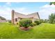 Brick house backyard featuring a manicured lawn and mature shrubbery, creating a private outdoor space at 1105 Sarah Ct, Greenwood, IN 46142