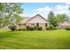 Brick house backyard with a spacious lawn and green shrubs, offering a peaceful setting at 1105 Sarah Ct, Greenwood, IN 46142