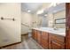 Bathroom featuring a double sink vanity with wood cabinets, accessible grab bars, and vinyl floors at 1105 Sarah Ct, Greenwood, IN 46142