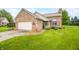 Charming brick home with well-manicured lawn, attached garage and meticulously landscaped entryway at 1105 Sarah Ct, Greenwood, IN 46142