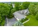 Aerial view of a well-maintained home featuring a circular driveway, manicured lawn, and mature trees in a private setting at 11823 E 200 S, Zionsville, IN 46077