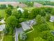 Stunning aerial view of a secluded home with lush landscaping, pool, barn, and pond, set amidst verdant fields at 11823 E 200 S, Zionsville, IN 46077