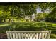 Secluded backyard view with mature trees, green lawn, and a charming house in the background, seen from a relaxing swing at 11823 E 200 S, Zionsville, IN 46077