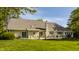 Spacious backyard with a wooden deck featuring outdoor seating and dining areas, surrounded by a lush lawn and mature trees at 11823 E 200 S, Zionsville, IN 46077