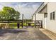 Exterior view of a white barn with a horse paddock, featuring mature trees and lush green grass at 11823 E 200 S, Zionsville, IN 46077