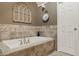 A beautifully tiled bathtub with updated fixtures and a decorative window sits beneath an elegantly painted wall at 11823 E 200 S, Zionsville, IN 46077